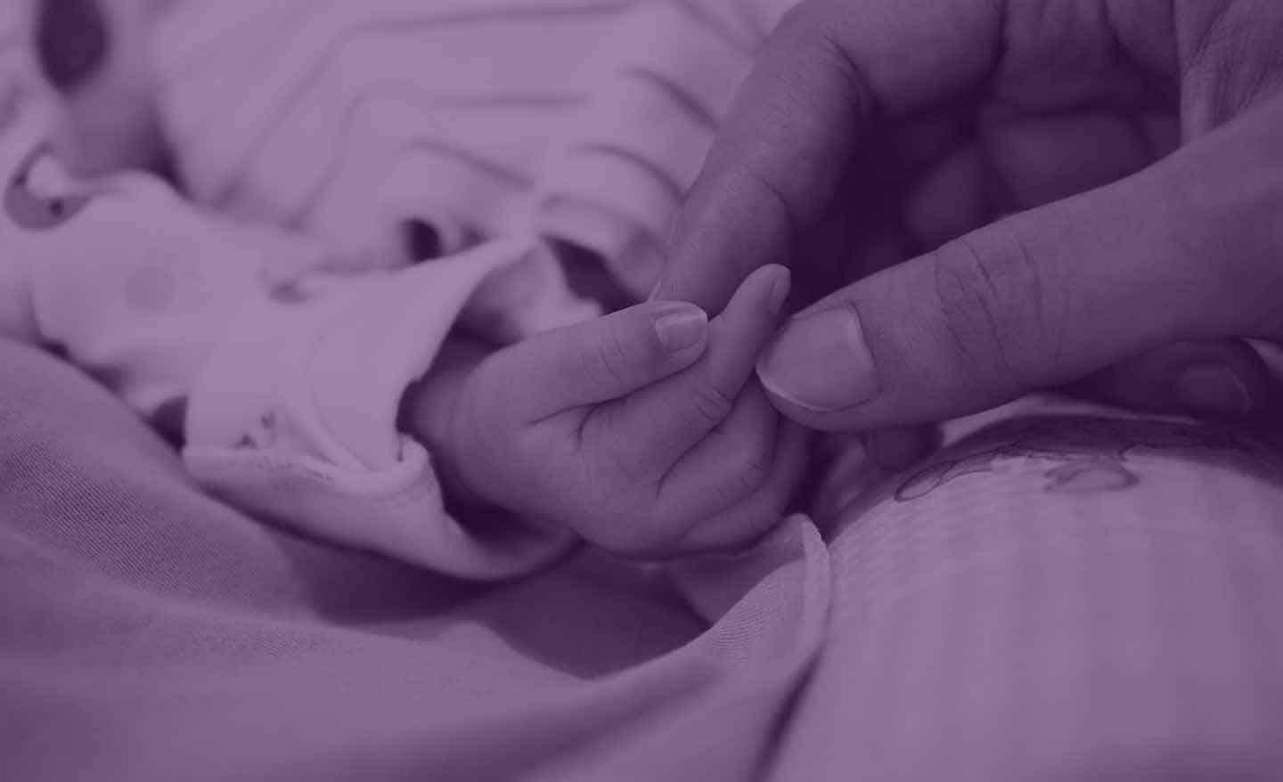 Mother holding baby's finger