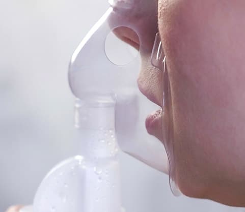 Person using nebulizer and inhaler for the treatment
