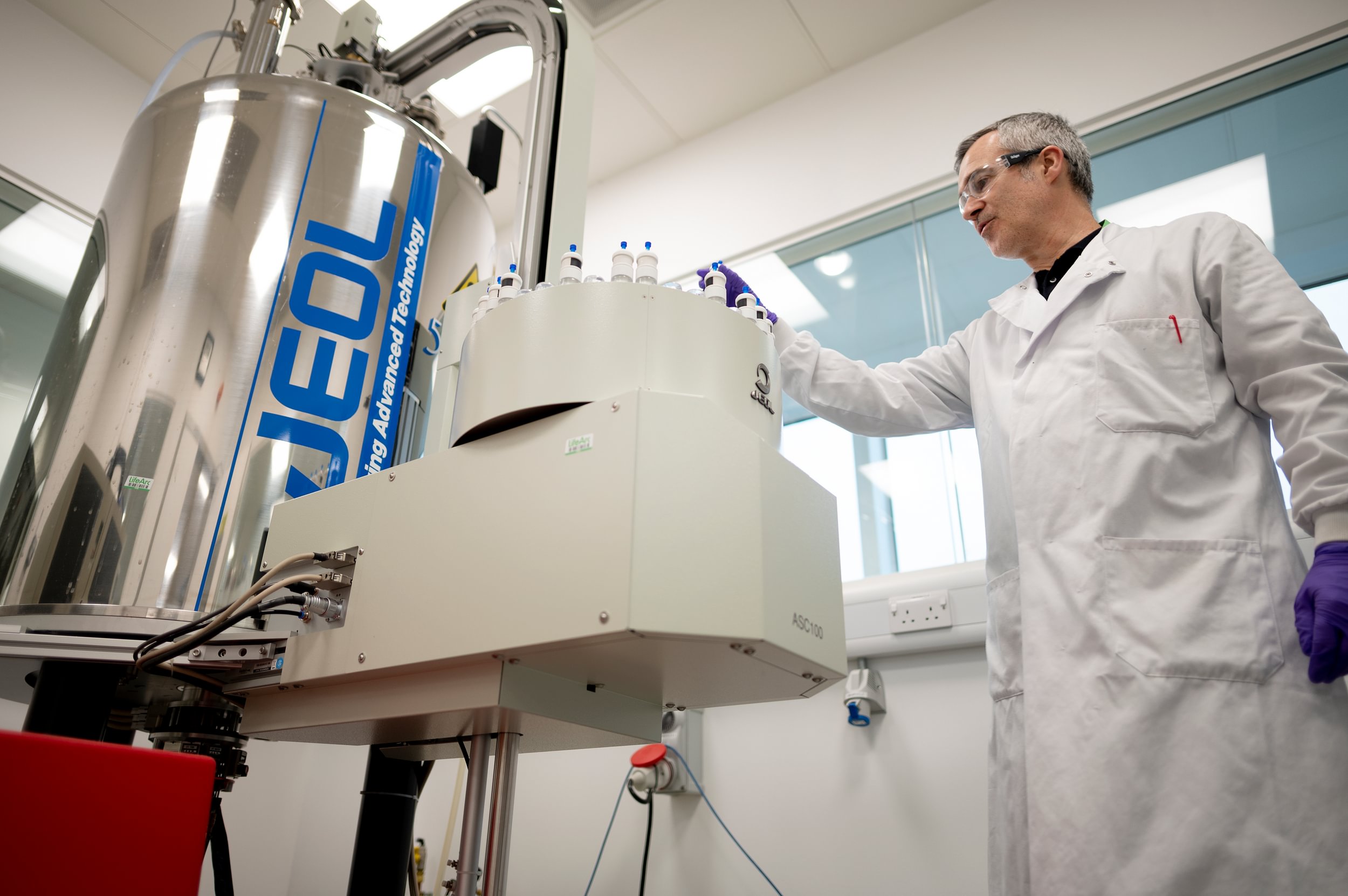 LifeArc scientist Kevin Gillen loads samples into a large cylindrical lab machine