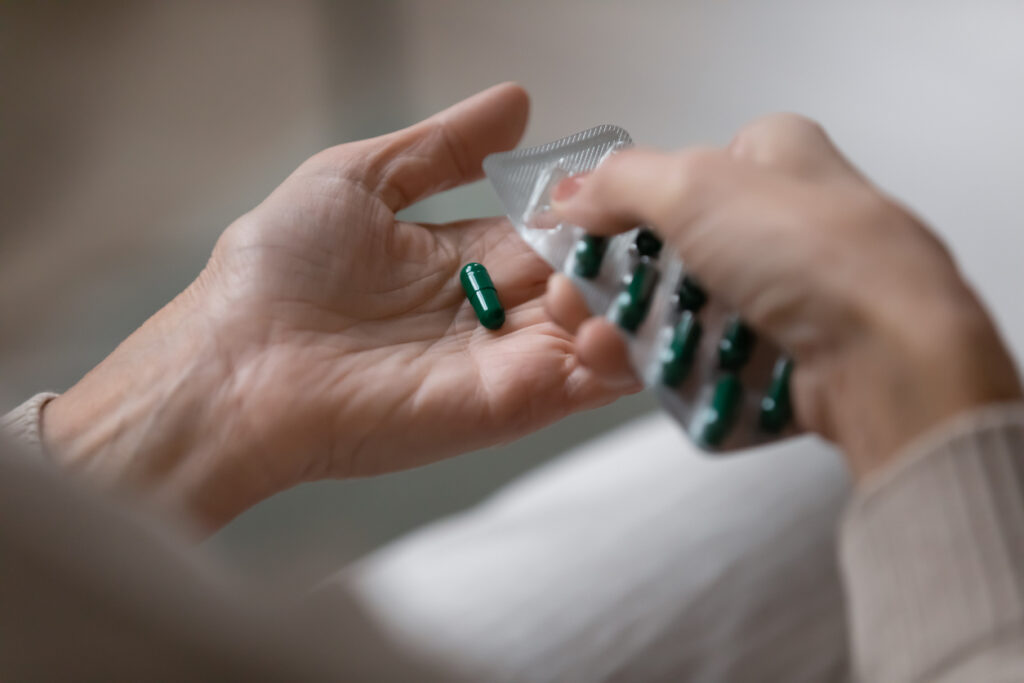 Close up of female hand holding pharmaceutical blister pack with oral capsules