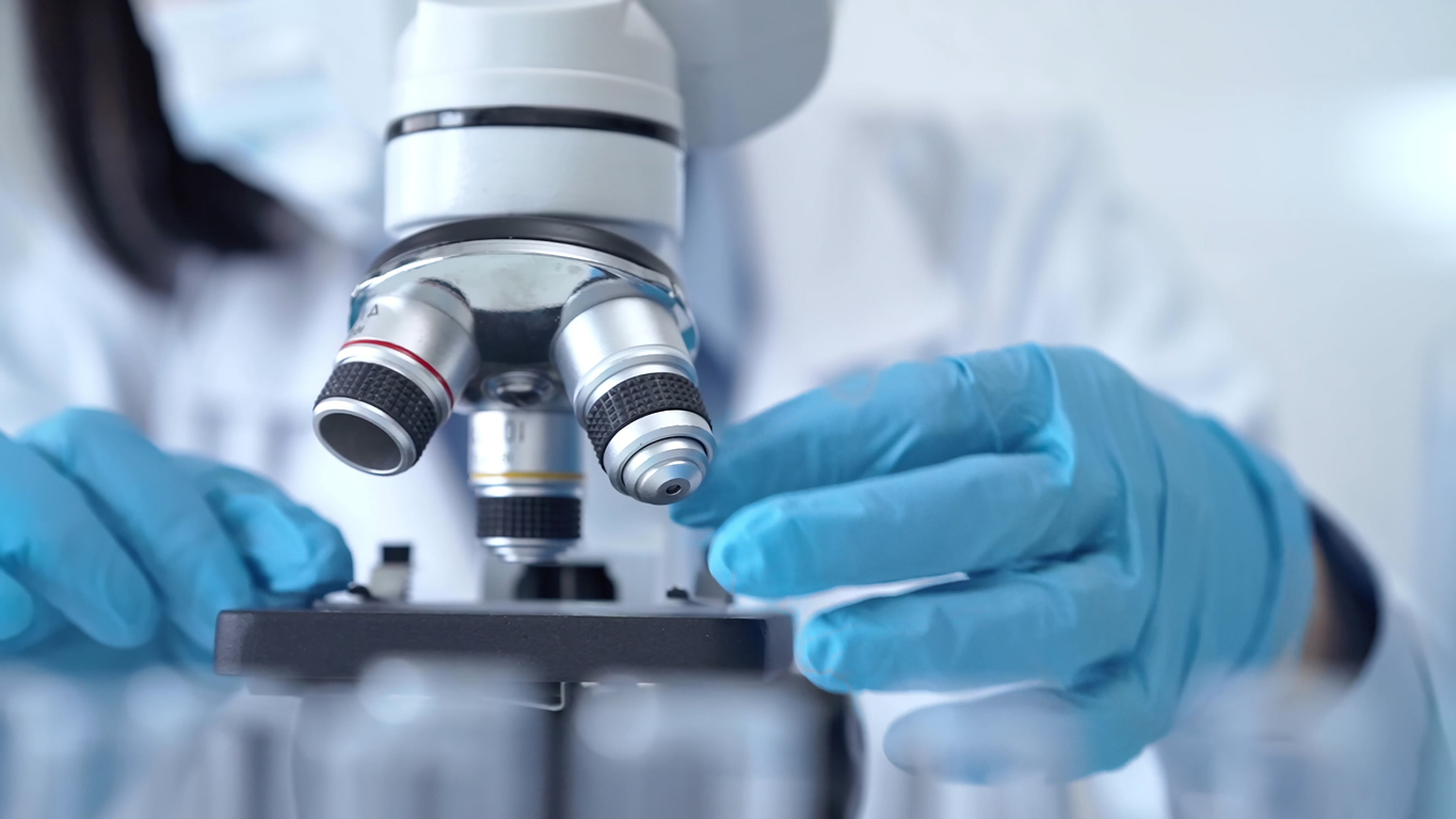 Scientist using microscope in laboratory.