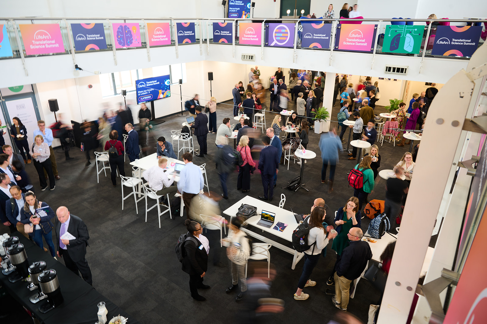 A busy hall of conference delegates networking and connecting with one another.