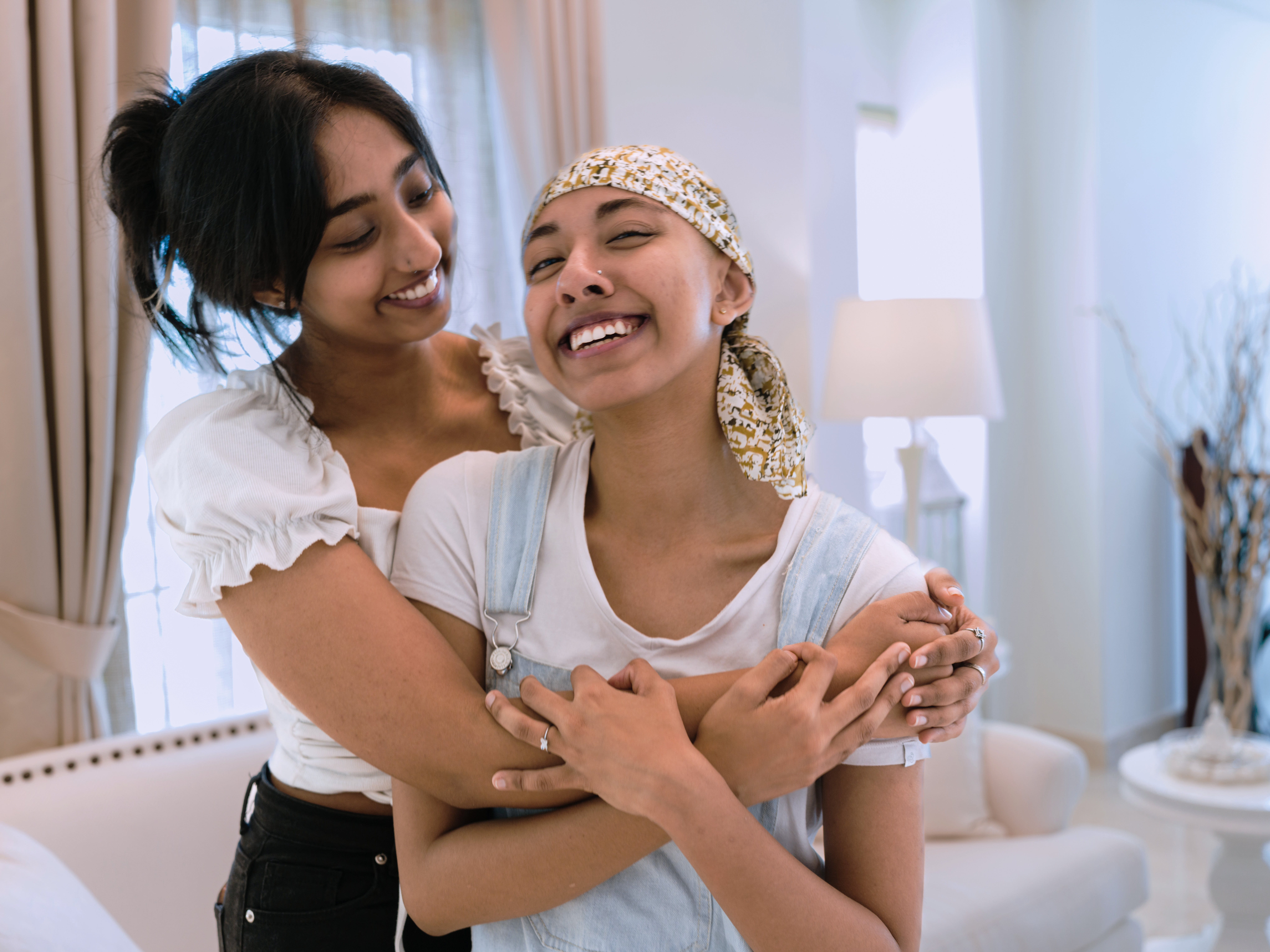 Image of Mother and teenage daughter embracing and smiling.