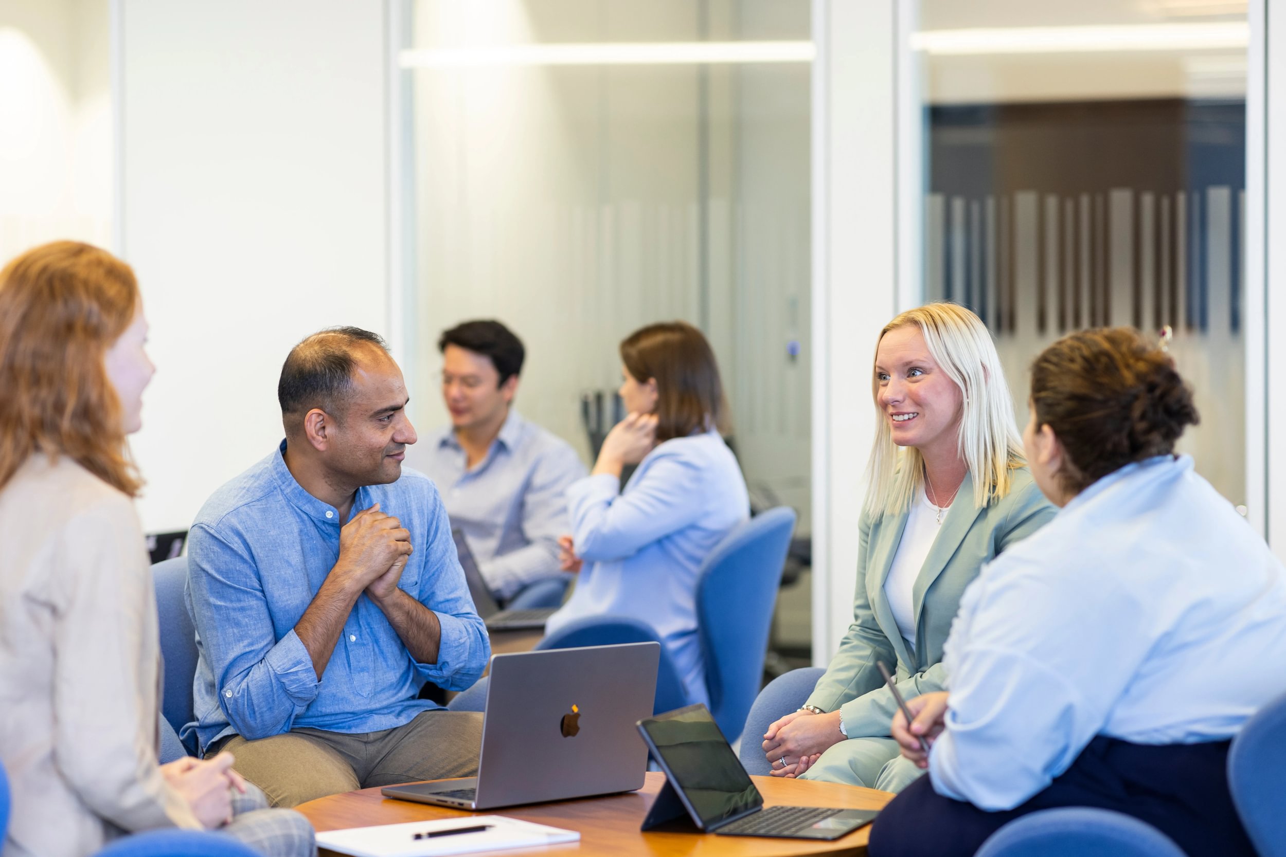 Four LifeArc Knowledge Transfer Innovation Fellows sat around a desk working and conversing