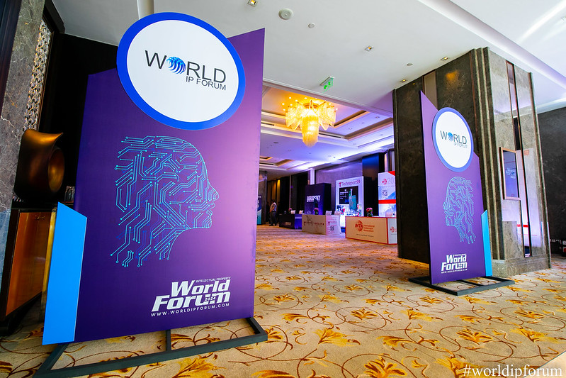 Conference hall with two large banners with logos for The World IP Forum
