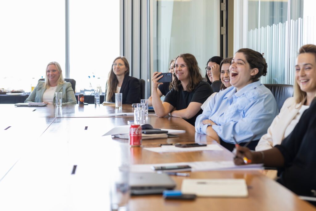 LifeArc Fellows sat around a meeting room smiling and laughing