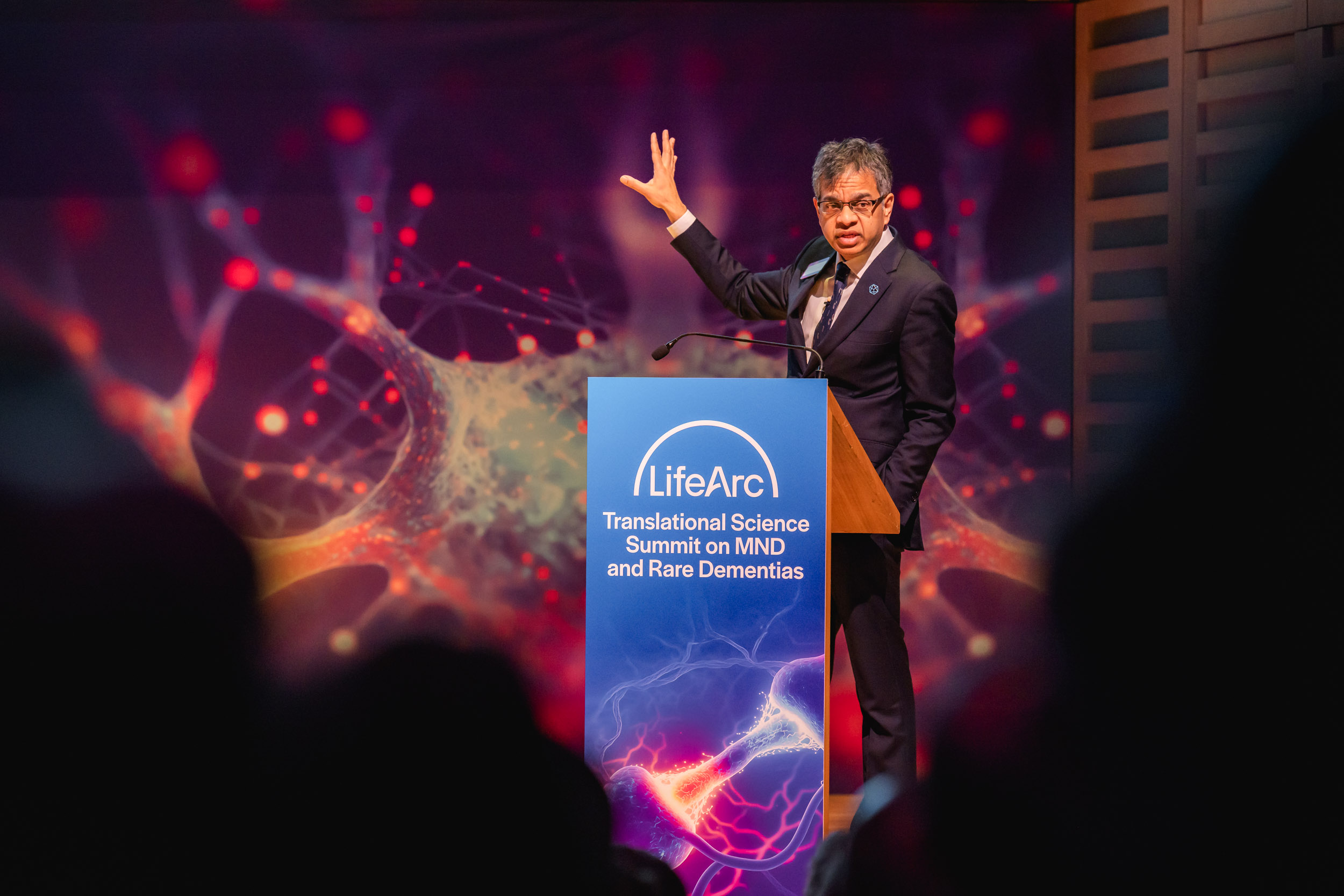 Siddharthan Chandran delivering presentation on stage at the LifeArc Translational Science Summit for MND and Rare Dementias