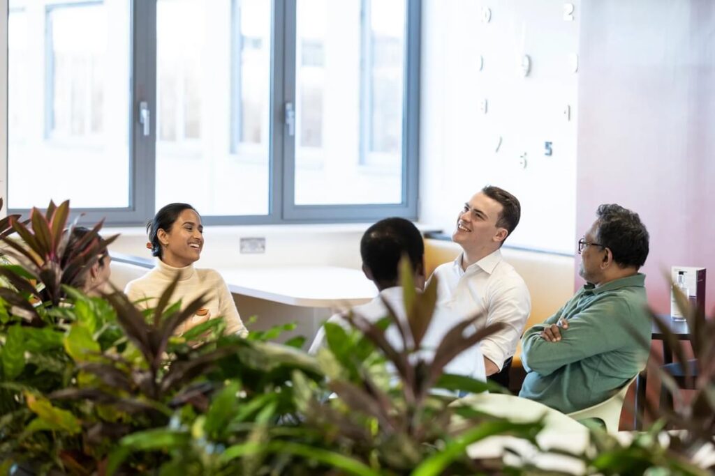 A happy team of people sit together in communal office areas