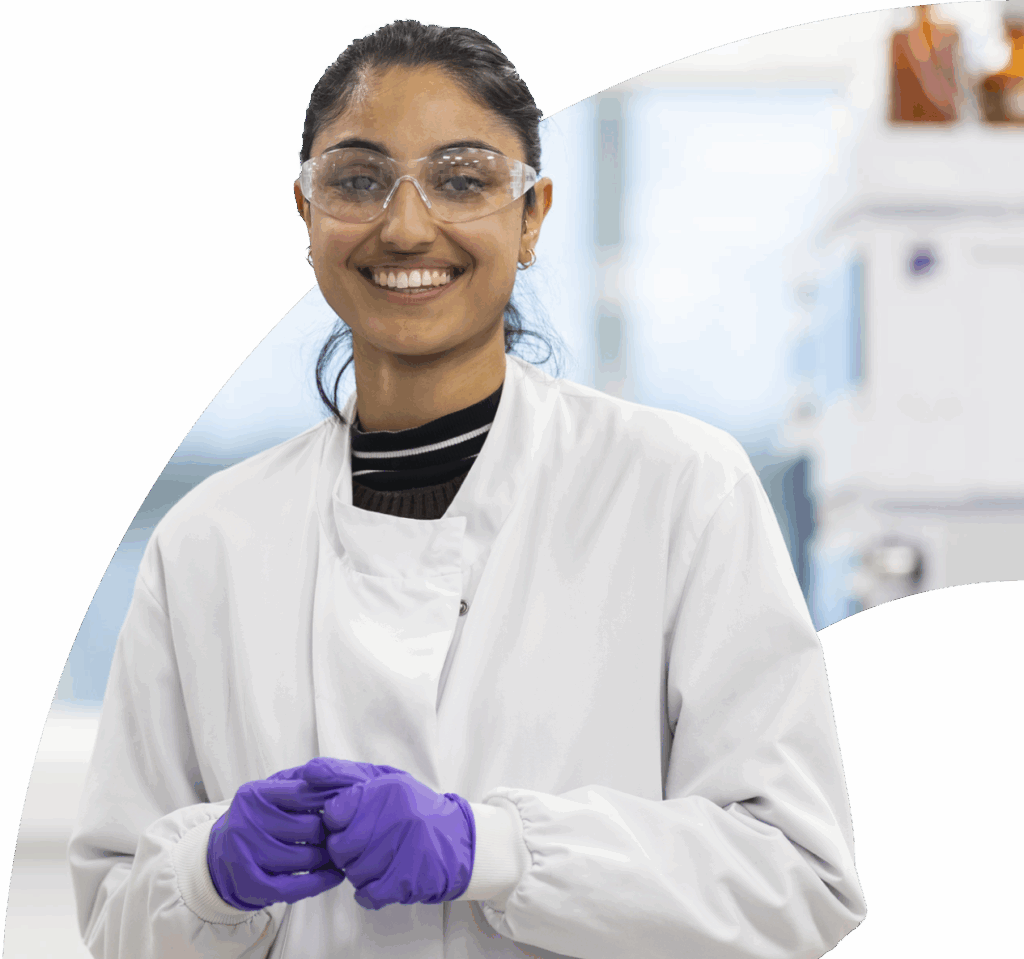 Girl smiling in a lab wearing PPE
