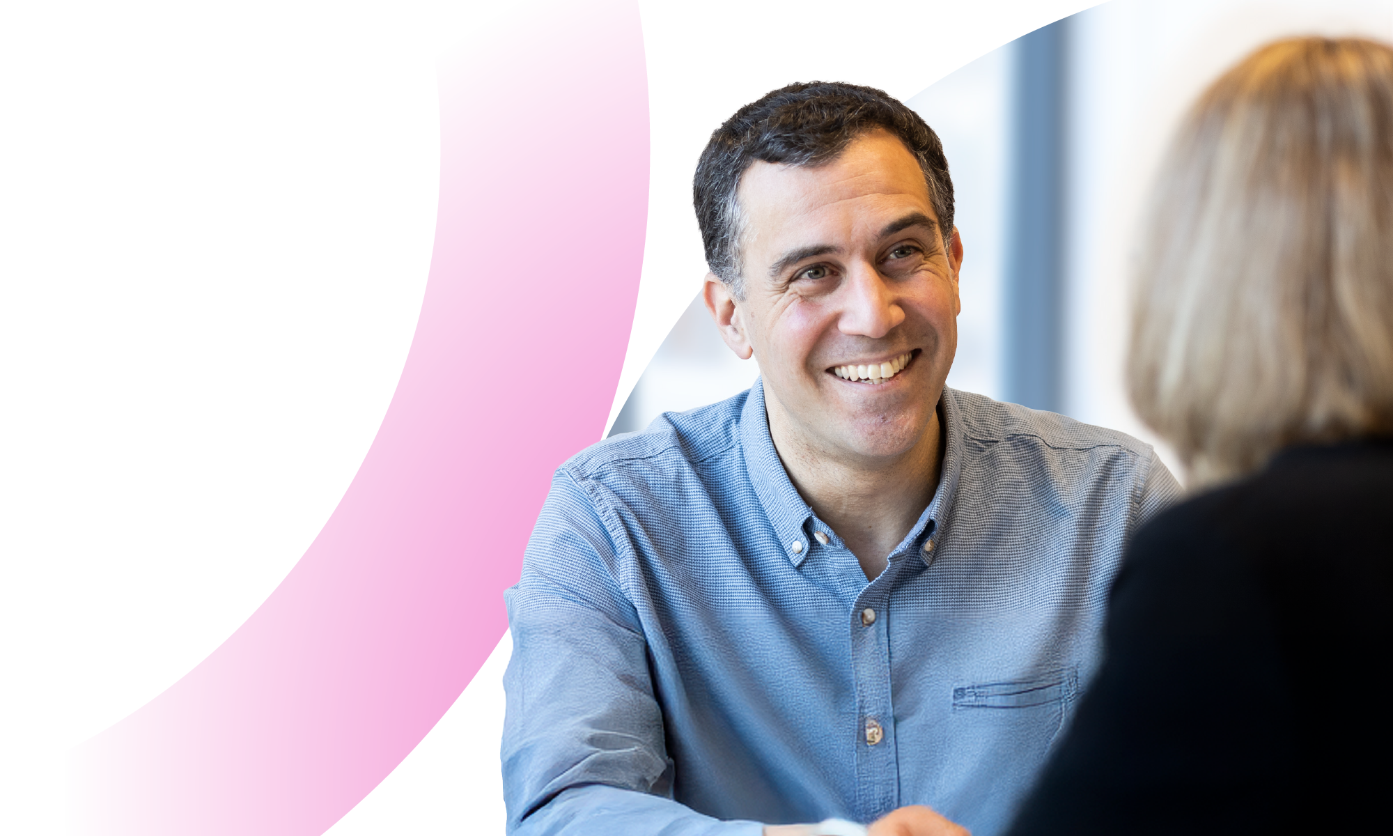 Male LifeArc colleague smiling and chatting with female colleague