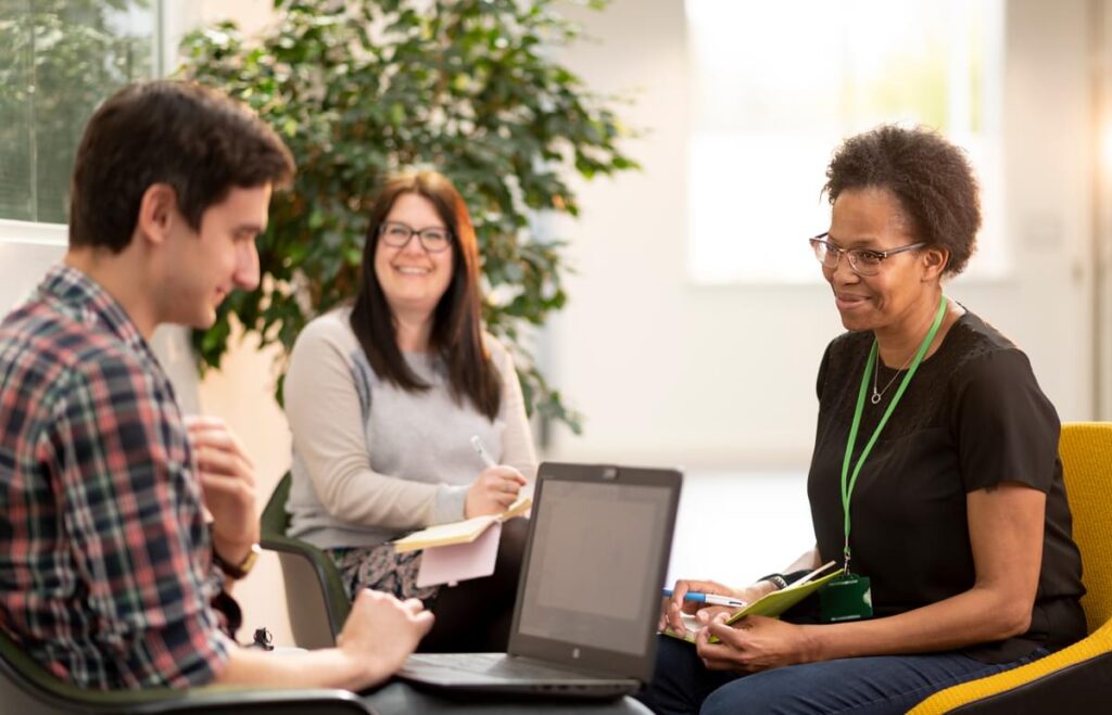 LifeArc staff having a conversation around a laptop