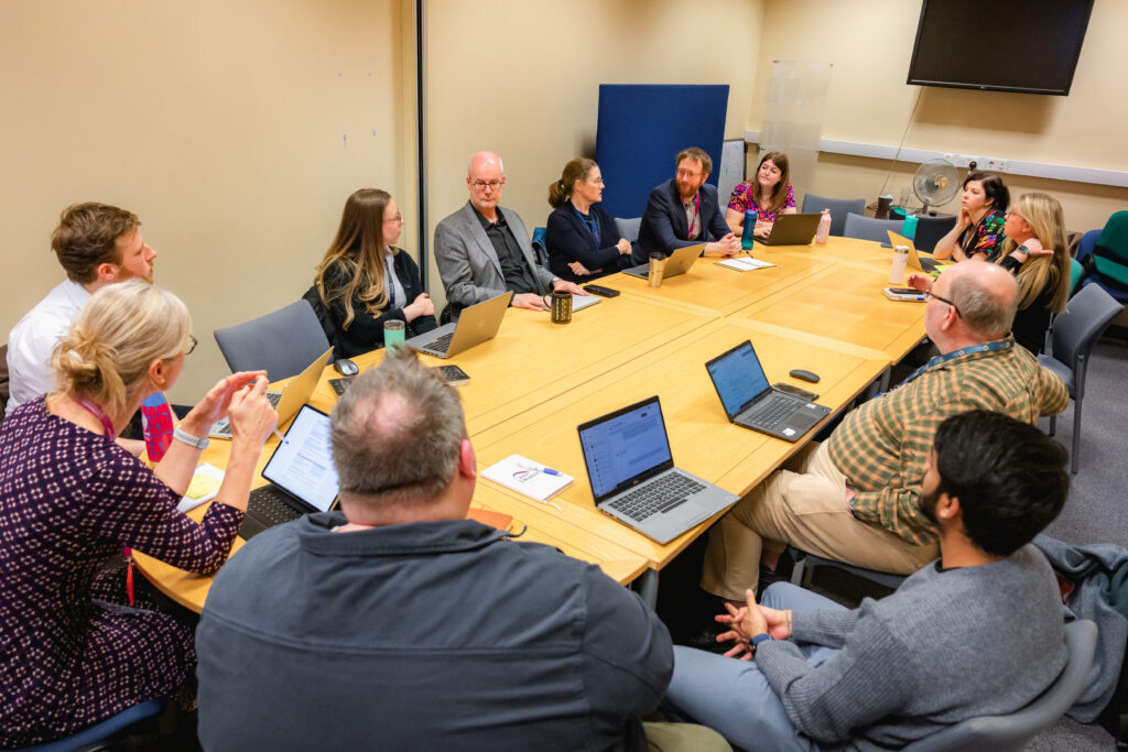 LifeArc Centre for Acceleration of Rare Disease Trials having a team meeting sat around a table